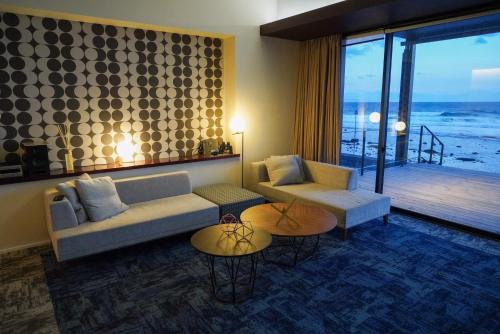 a living room with a couch and tables and a balcony at Sinori205 in Hakodate