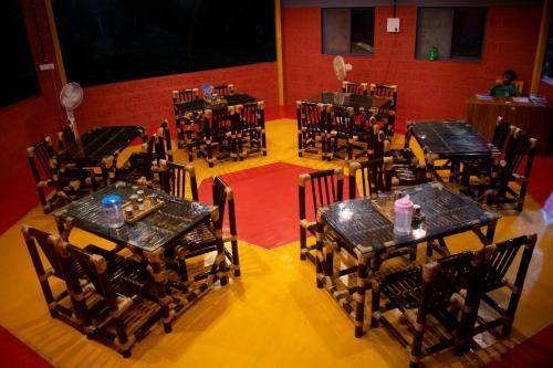 einen Blick über ein Restaurant mit Tischen und Stühlen in der Unterkunft amee's retreat in Diveagar