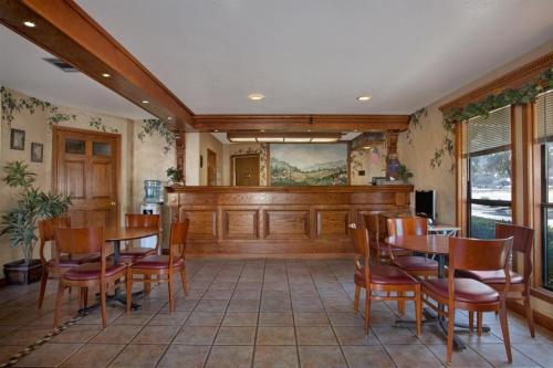 a dining room with wooden tables and chairs at Travelodge by Wyndham Lemoore Near Naval Air Station in Lemoore