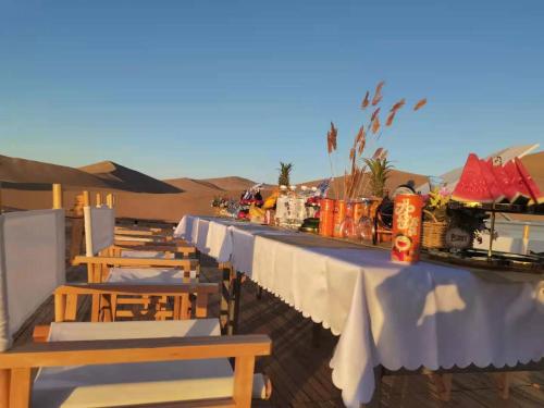 a row of tables and chairs in the desert at Ming Sha Mountain Wild Hostel in Dunhuang