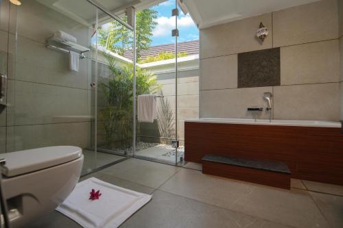 a bathroom with a toilet and a shower and a sink at Gokulam Grand Resort & Spa, Kumarakom in Kumarakom