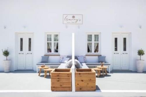 a living room with a couch and tables and windows at Grannys Villas finiki in Karpathos Town