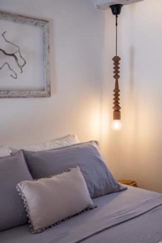 a bed with a pillow and a light fixture at Grannys Villas finiki in Karpathos Town