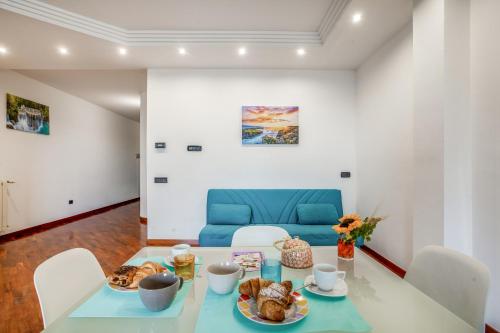 jadalnia ze stołem i niebieską kanapą w obiekcie Bari Waterfront Apartment w mieście Bari