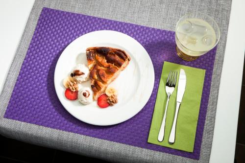 a plate of food with waffles and strawberries on a table at Ibis Lleida in Lleida