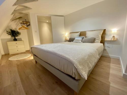 a bedroom with a large bed with white sheets at Montignac-Lascaux - Les Pierres d'Alexandre in Montignac