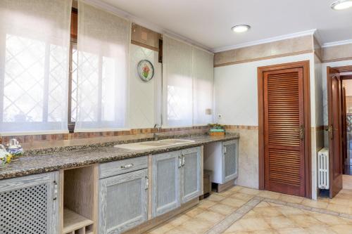 cocina grande con fregadero y ventana en Gran Chalet céntrico con piscina y bbq privada a 5 minutos playa, en Alicante