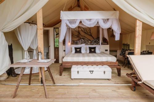 ザグレブにあるZaluka Urban Glampingの天蓋付きの大きなベッドのある寝室