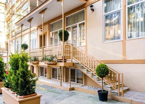 a building with stairs and potted plants in front of it at BB Residence Sololaki in Tbilisi City