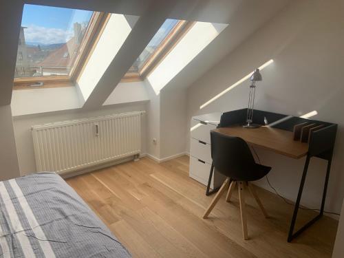 a bedroom with a desk and a bed with skylights at Apartment Wendelsteinblick in Bad Aibling