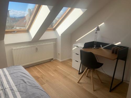 - une chambre avec un bureau et un lit avec des lucarnes dans l'établissement Apartment Wendelsteinblick, à Bad Aibling