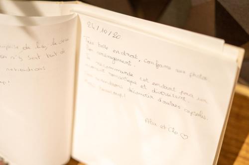 an open book with handwriting on the pages at Capsule Temps suspendu - balnéo, home cinema & billard in Valenciennes