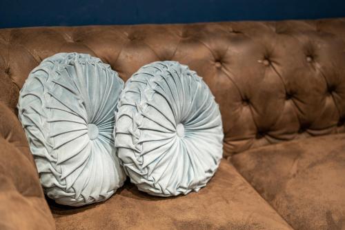 two pillows sitting on top of a couch at Capsule Temps suspendu - balnéo, home cinema & billard in Valenciennes