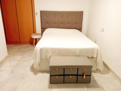 1 dormitorio con 1 cama y 2 cajas en el suelo en Encantador ático con chimenea y piscina en Almería, en Retamar