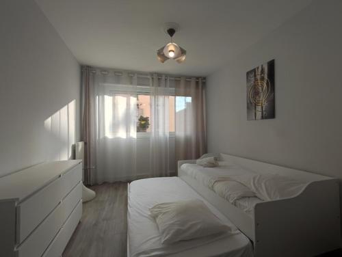 - une chambre blanche avec 2 lits et une fenêtre dans l'établissement Port, vue mer, parking et confort, à Nice