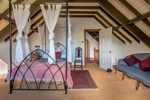 a bedroom with a canopy bed in a room at Stunning baptist chapel with concert piano, pets welcome in Higher Wambrook