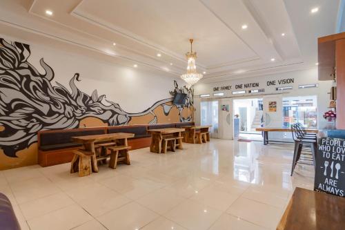 a restaurant with wooden tables and a mural on the wall at Urbanview Hotel One Family Maribaya by RedDoorz in Lembang