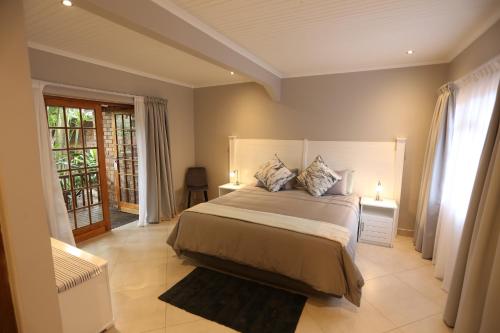 a bedroom with a large bed with two lamps at Rhino Coast Guesthouse in St Lucia