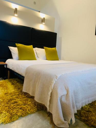une chambre avec un grand lit avec des oreillers jaunes dans l'établissement 45BB Apartment, à Carcassonne