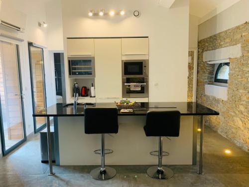 eine Küche mit Theke und zwei Barhockern in der Unterkunft 45BB Apartment in Carcassonne