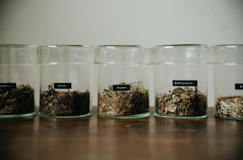 a row of glass containers filled with different types of herbs at Hostel Saruya in Fujiyoshida
