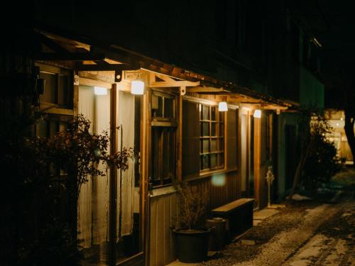 a house with lights on the side of it at night at Hostel Saruya in Fujiyoshida