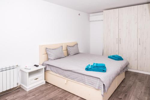 um quarto com uma cama com toalhas azuis em Luxure apart Alex em Sófia