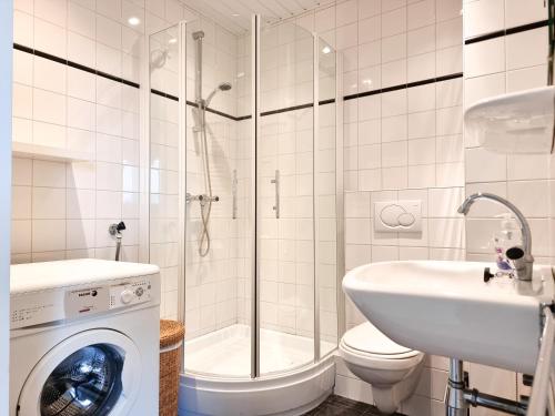 a bathroom with a shower toilet and a washing machine at Vakantie appartement Chava WE09 in Westkapelle