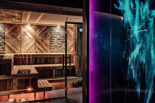 a room with a glass shower with purple lights at Alpin Garden Luxury Maison & SPA - Adults Only in Ortisei