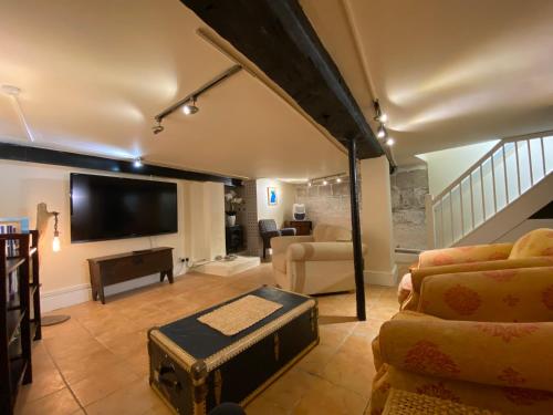 a living room with a flat screen tv and a couch at The Old Rope House in Portland