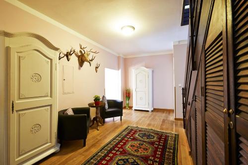 a living room with a door and chairs and a rug at Hotel Elch in Nuremberg
