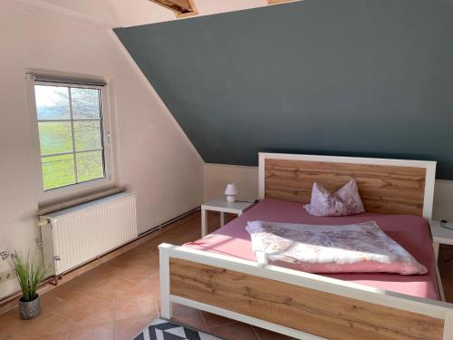 - une chambre avec un lit avec des draps roses et une fenêtre dans l'établissement Ferienwohnung mit Blick auf die Burg Stargard, à Burg Stargard