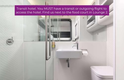 a bathroom with a sink and a toilet and a mirror at YOTELAIR Amsterdam Schiphol Transit Hotel in Schiphol