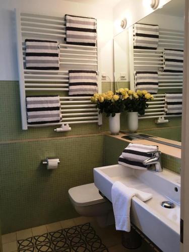 a bathroom with a sink and a toilet and a mirror at Wiesenhüs in Tinnum
