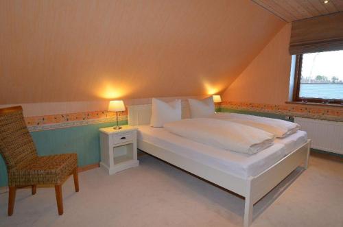 a bedroom with a large white bed and a chair at Theodor Heuss in Westerland