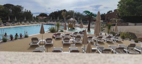 - un groupe de chaises longues et de parasols à côté de la piscine dans l'établissement Baia 1, à Drammont