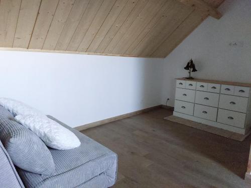 a bedroom with a couch and a dresser in a room at GITE HARY in Villeblevin