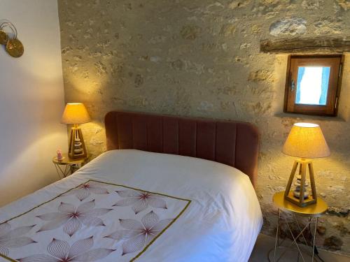 una camera da letto con un letto con due lampade sui tavoli di Les Roses a Barjou