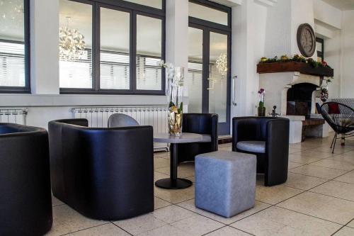 ein Restaurant mit einem Tisch, Stühlen und einem Kamin in der Unterkunft Hôtel Le Robinson in Beaucaire