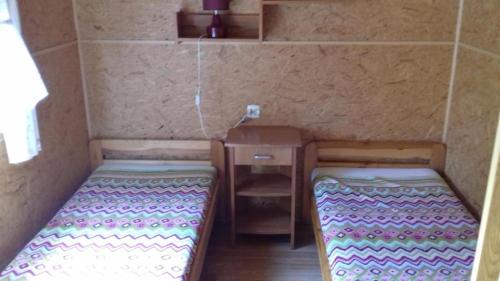a small room with two beds and a table at Cichy Zakątek Junoszyno in Junoszyno