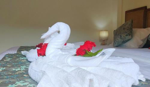 Un cisne hecho de toallas en una cama en Mountain View Hotel, en La Digue