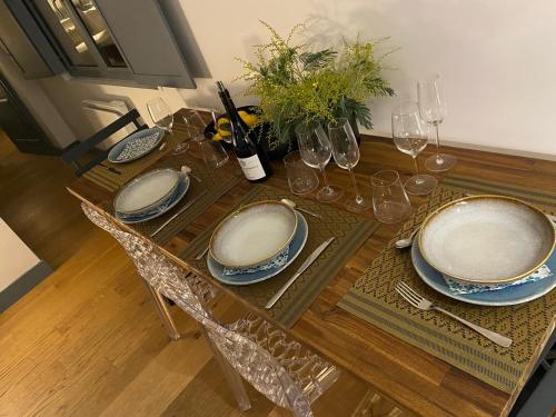 - une table à manger avec des assiettes et des verres à vin dans l'établissement Appartement de standing 4 étoiles plage Pereire à pied 100m, à Arcachon