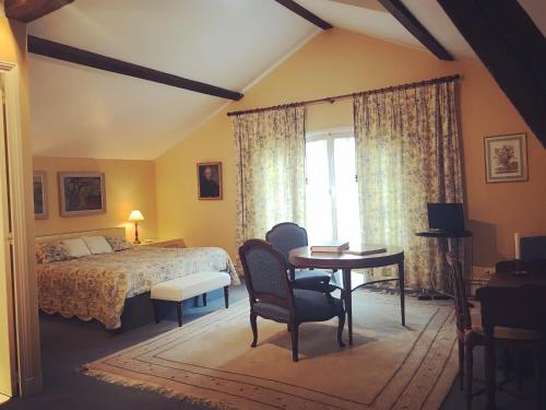 a bedroom with a bed and a desk and a table at Chambre d'hôte Manoir de Clairbois in Larçay