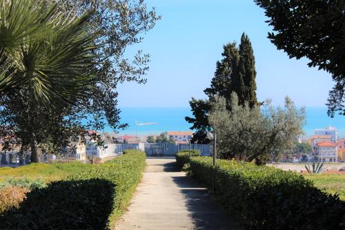 a walking path in a park with trees and bushes at Ostello e Camere Private Prima Luce Foresteria in Giulianova