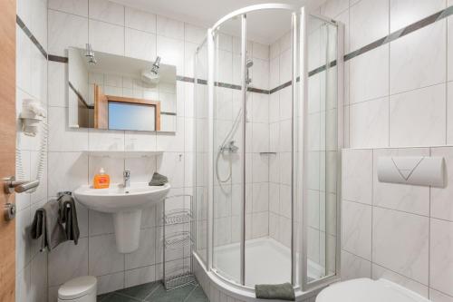 a bathroom with a shower and a toilet and a sink at Die Landpension FernW in Willingen