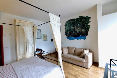 een slaapkamer met een bed en een bank bij B&B Nest on the Lake in Lezzeno