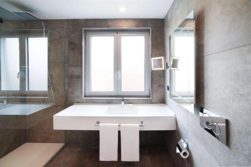a bathroom with a white sink and a window at Radisson Blu GHR Rome in Rome