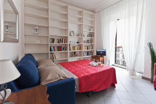 een woonkamer met een tafel, een bank en boekenplanken bij Gianicolo Holiday House in Rome