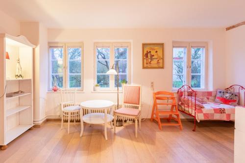 Emmelsbüll-HorsbüllにあるRikes Ferienhausのリビングルーム(テーブル、椅子、ベッド付)
