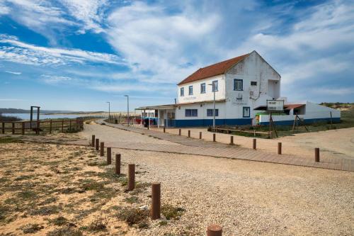 a building on the side of a dirt road at apart@CostaSantoAndré Beach in Santiago do Cacém